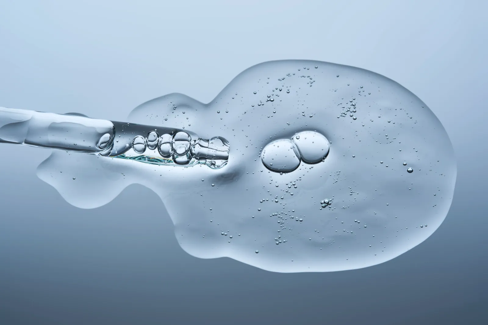 serum-droplet-close-up-with-dropper-over-blue